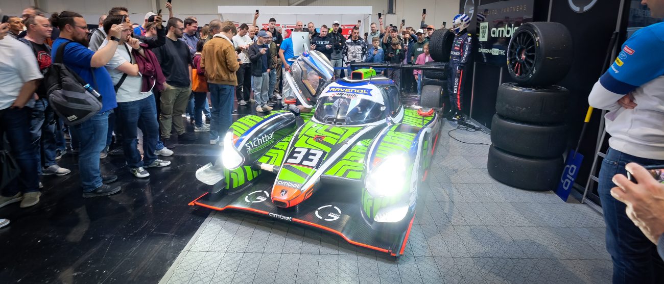 GCOM360-Messestand auf der SimRacing Expo 2025 mit LMP3-Rennwagen