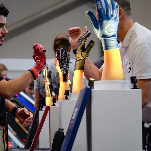 Vier getragene SRG1 in Schwarz, Gold, Rot und Blau beim Anprobieren am Messestand